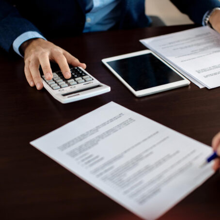 closeup-financial-consultant-going-through-paperwork-meeting-with-client